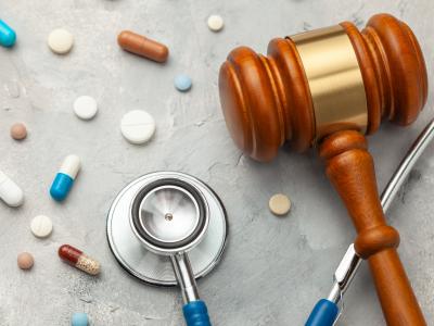 Judge gavel and stethoscope with pills. The law in medicine, the sentence on medical negligence.